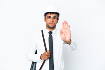 Architect brazilian man with helmet and holding blueprints making stop gesture