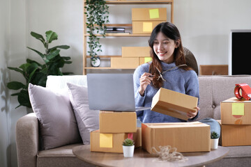 Fototapeta na wymiar Young woman small business owner working at home office. Online marketing packaging delivery, startup SME entrepreneur or freelance woman concept. Small business owener