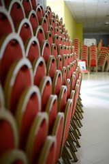 rows of red and gold cinema and theater chairs for spectators and audiences

