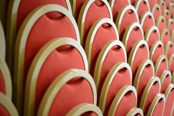 rows of red and gold cinema and theater chairs for spectators and audiences
