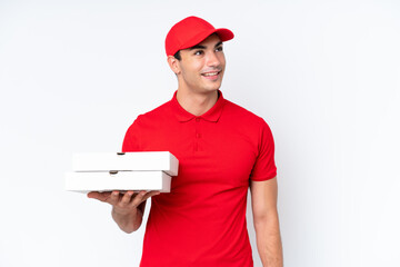 Pizza delivery caucasian man with work uniform picking up pizza boxes isolated on white background thinking an idea while looking up