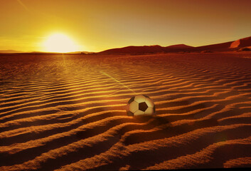 Soccer Ball on Qatar desert by sunrise