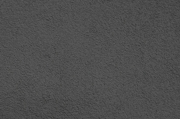 Gray decorative plaster of an exterior wall on a sunny day.Abstract textured gray background.