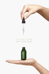 Skincare cosmetic ads. Graceful female hands holding a cosmetic dropper bottle over a white background with copyspace - 530845801