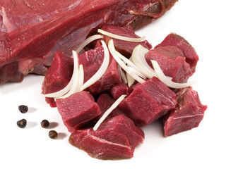 Wildschweinfleisch roh  - Fleisch Würfel für Gulasch mit Zwiebel und Pfeffer.  Freigestellt auf...