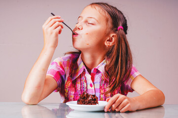 Beautiful happy young girl eating chocolate cake. Horizontal image.