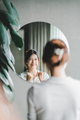 Asian woman looking through the mirror and confident of herself. cheer yourself up