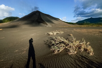 Shadow silhouette of tourist taking photos in front of Yasur Volcano, Tanna Island, Vanuatu