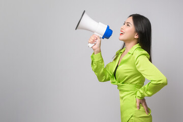 Young beautiful woman holding megaphone over white background studio..