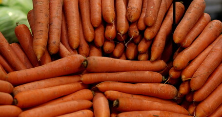 Many carrots piled together at grocery store on display