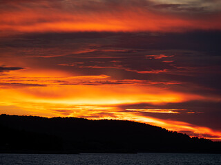 a wonderful orange sunset with the sea and land in the background