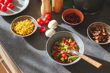 Sunliht modern kitchen with plate of quinoa filled with vegetables and ingredients on the countertop.