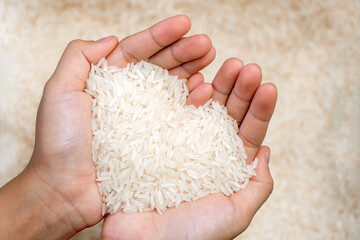 The jasmine rice seeds on the woman hands resemble hearts.