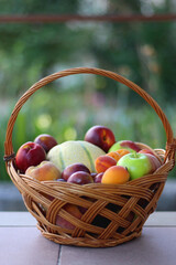 Vintage basket full of seasonal fruit in the garden. Selective focus.