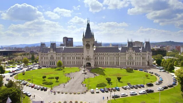 Aerial drone view of the Palace of Culture in Iasi downtown, Romania. Square with Stephen the Great statue, people and greenery in front of it, multiple buildings around