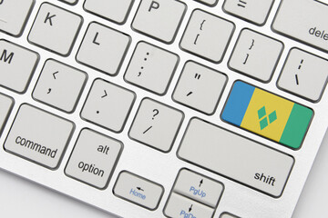national flag of saint vincent and the grenadines on the keyboard on a grey background .3d illustration