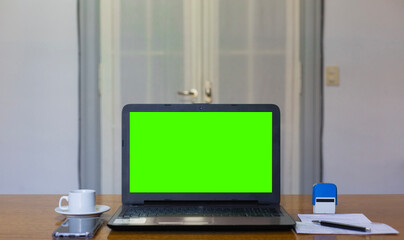 Close up view of doctor's office laptop with mock up green screen browsing internet at work desk....