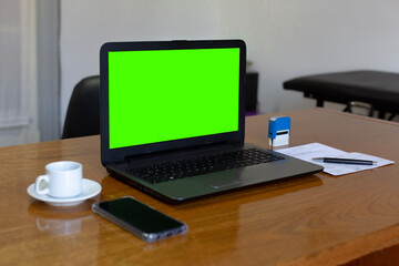 Close up view of doctor's office laptop with mock up green screen browsing internet at work desk. Healthcare medical e health website technology concept.