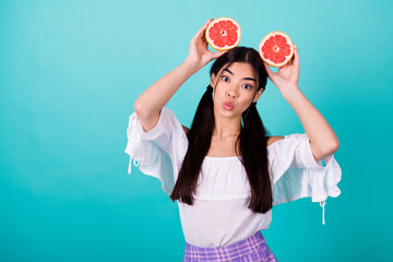 Photo of adorable sweet girl dressed off shoulders blouse lips plump empty space rising head citrus slices isolated teal color background