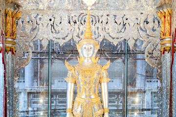 Obraz premium Deity statue standing straight made of silver, wearing silver gold costume with Chada on top of his head. Surrounded by sparkleling decoration.