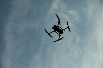Drone in sky. Quadro copter flies in air. Surveillance from height. Four propellers.