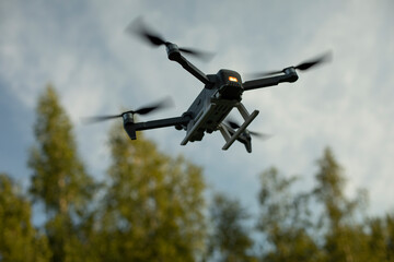 Drone flies low. Drone flight in sky. Technology of flight and shooting from sky. Device with propeller.