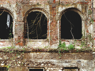 Abandoned building with arched window openings. Arched window openings without glass. House with ghosts.