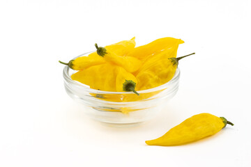 Yellow ripe Lemon Drop peppers in glass bowl isolated on white background. Hot chili peppers with...
