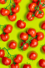 Tomato on a branch sprout top view flatlay on a yellow-green background. Fresh juicy ripe tomato Red Cherry fruits. Salad preparation ingredients