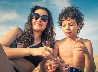 Older sister and little brother brunettes eat cotton candy at sea