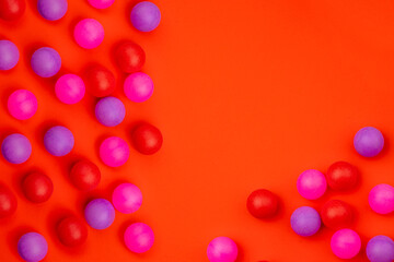 Abstract colored balls background. Multi-colored taw toy scattered on bright paper. Base for design nice backdrop, wallpaper, poster. Noisy surface texture