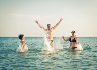 Dad, daughter and son bathe swimming in the sea and having fun together. Paternity concept