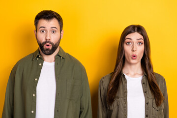 Portrait of two shocked partners pouted lips look camera unbelievable isolated on yellow color background