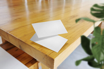 Clean minimal business card mockup floating on top table with leaves