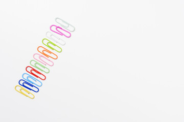 Top view colorful paper clips isolated on white background. High key photography.