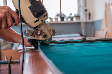 The cutter cuts the fabric with a disc knife in a sewing workshop
