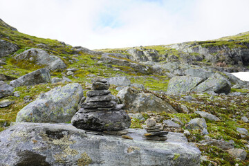 Fototapeta na wymiar aufgetürmte Steine mit Blick auf die Landschaft im Aurlandsfjellet in Norwegen