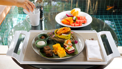 Tray with various sweet dessert cakes, patisseries, croissant, fruits