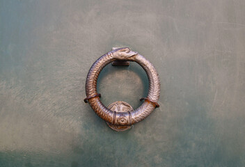 Close-up of a door knocker in the shape of an uroboros, an ancient symbol depicting a serpent (or...