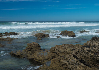 View sea shore with ocean waves, sharp rocks and stones at Rota Vicentina wild coast near Porto Covo, Portugal.