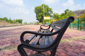 Blank railway sign board, seating bench at railway station platform of an Indian mountain village...