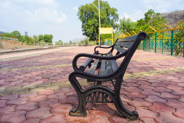 Blank railway sign board, seating bench at railway station platform of an Indian mountain village...
