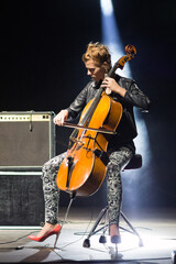 Young woman playing cello on the concert stage at night © Solid photos