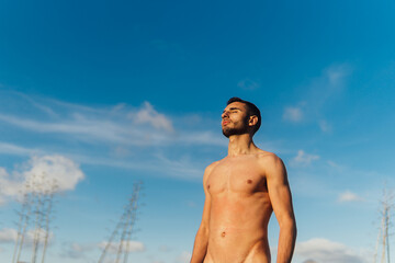 Nude man against blue sky in nature
