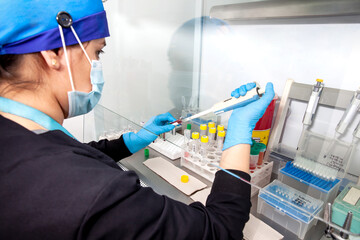 Young female scientist preparing blood samples for karyotipe and fluorescence in situ hybridization...