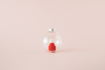 Transparent Christmas ball ornament with red Santa's hat inside. Minimal concept