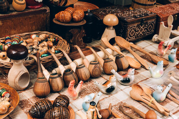 Various wooden handmade souvenirs at street market stall or souvenir shop for tourists. Wooden easter eggs pysanka, pipes, ceramic whistles. Traditional Ukrainian handicrafts