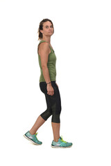 side view of a woman with sportswear walking and looking at camera on white background,