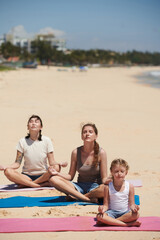 Fototapeta premium People Meditating on Sunny Beach