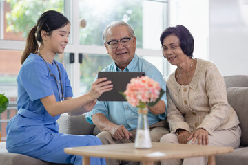Asian woman doctor work in nursing home with digital tablet consults service to patient explains...